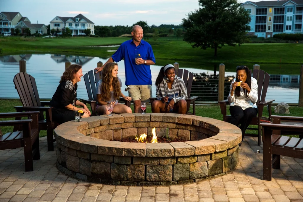 Group roasting marshmallows by fire outdoors
